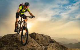 Cyclist Riding the Bike on Autumn Rocky Trail at Sunset. Extreme