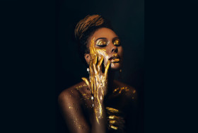 Artwork portrait closeup fantasy african woman face in gold pain