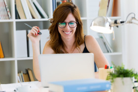 Beautiful young woman working with her laptop at home.