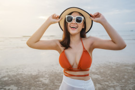 cheerful woman in bikini enjoying on sea beach