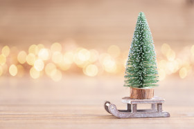 Colorful Christmas tree on wooden, bokeh background.